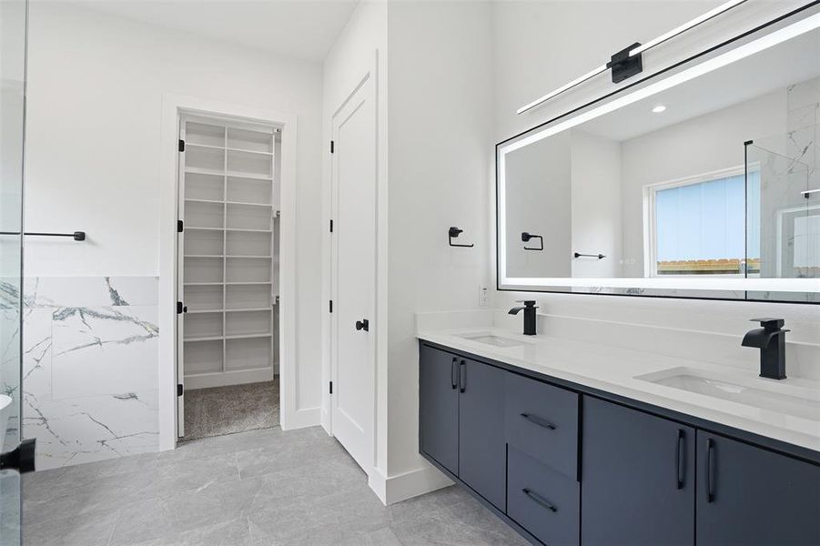Double vanity with matte black fixtures and an illuminated mirror
