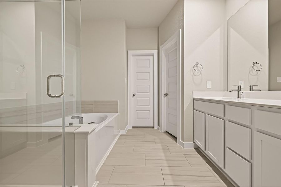 The primary bathroom features a separate shower area and a bathtub for added convenience and comfort.