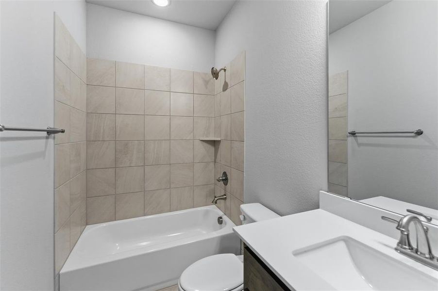 Bathroom with bathing tub / shower combination, vanity, and a textured wall