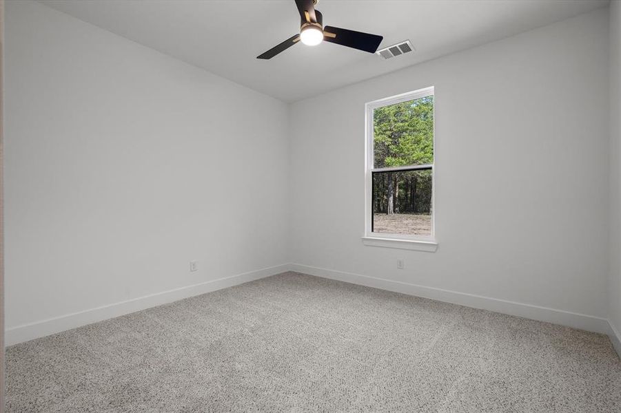 Unfurnished room featuring light carpet and ceiling fan