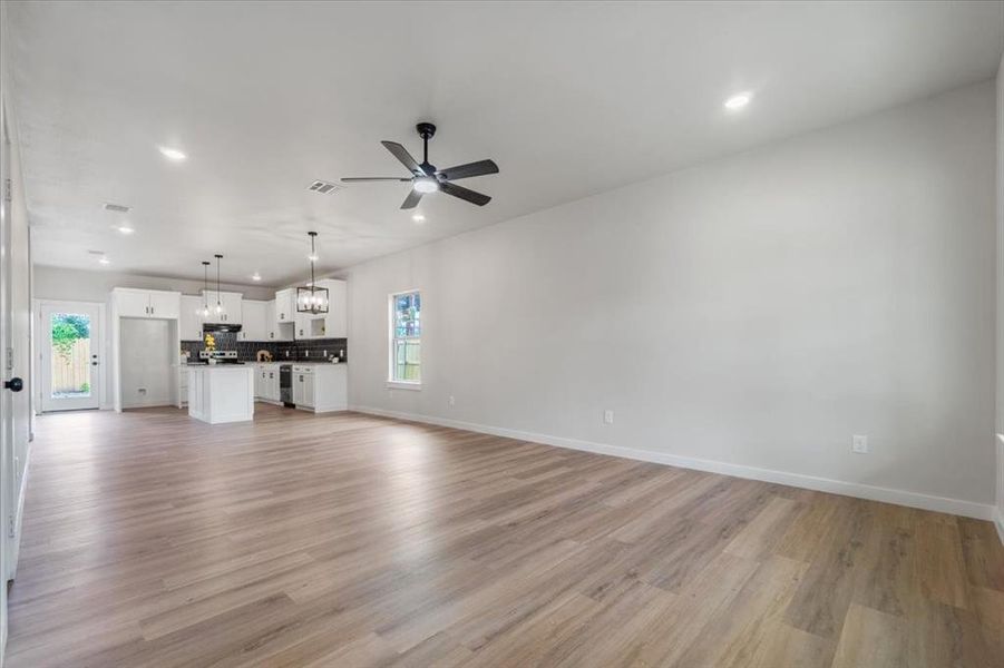 Unfurnished living room with light hardwood / wood-style floors and ceiling fan