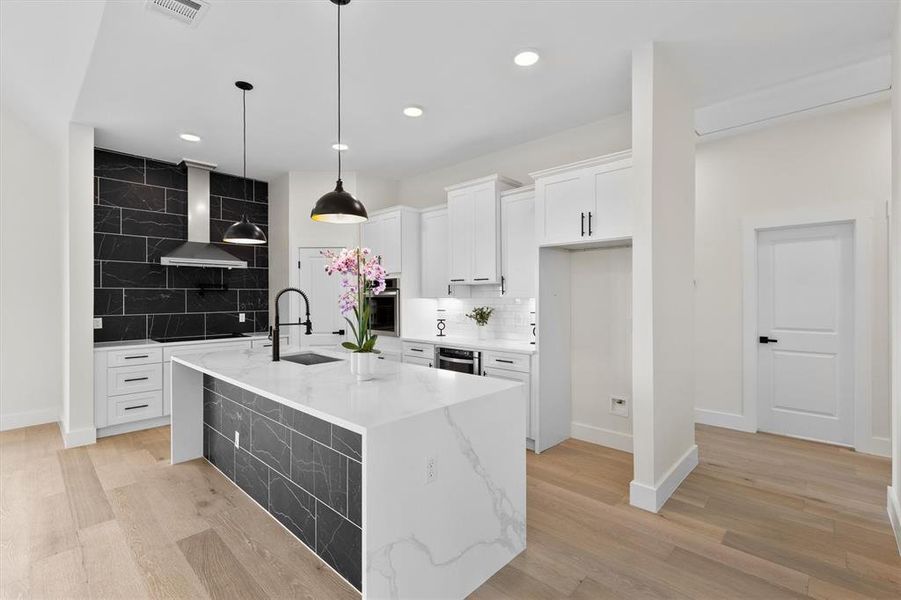 Kitchen with a sink, wall chimney exhaust hood, oven, decorative backsplash, and recessed lighting Kitchen with a sink, wall chimney exhaust hood, oven, decorative backsplash, and recessed lighting