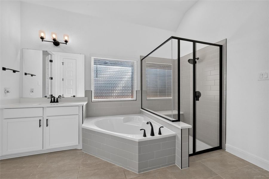 A spacious soaking tub and a separate glass-enclosed shower highlight this tiled bathroom. A spacious soaking tub and a separate glass-enclosed shower highlight this tiled bathroom.