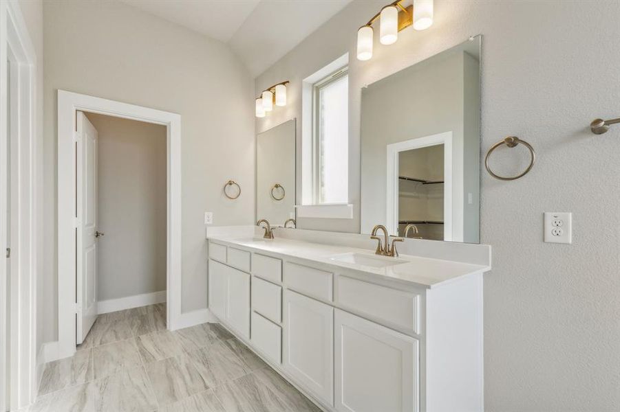 Bathroom featuring lofted ceiling and vanity