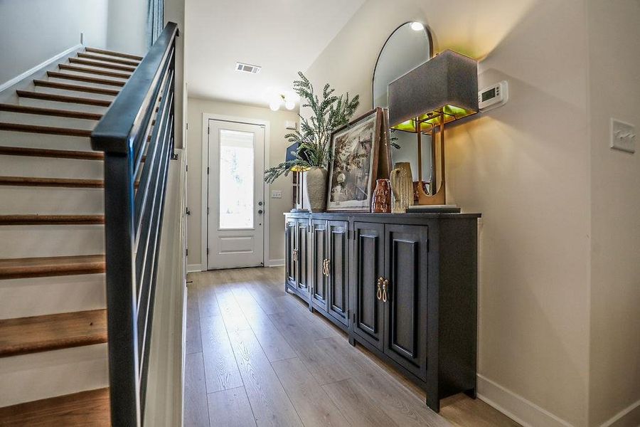 Foyer with stairs and light wood finished floors