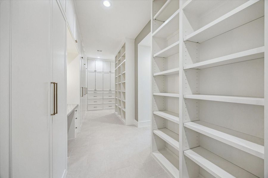 Second angle of Primary closet with adjustable shoe storage and abundance of drawer space. Full length dressing mirror on adjacent wall. Second angle of Primary closet with adjustable shoe storage and abundance of drawer space. Full length dressing mirror on adjacent wall.