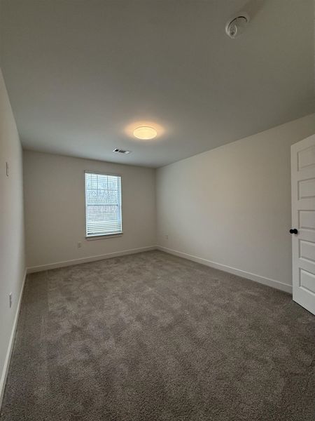 Carpeted spare room with baseboards