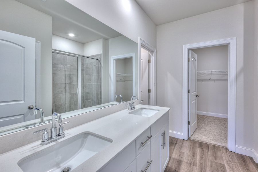 The primary bathroom offers dual vanity sinks and a walk-in closet.