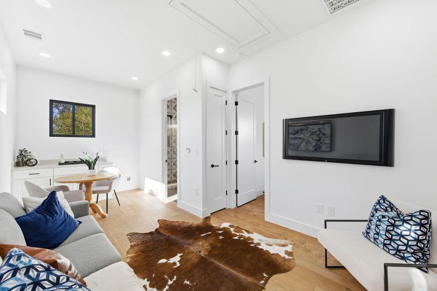 Living area featuring light wood finished floors and recessed lighting