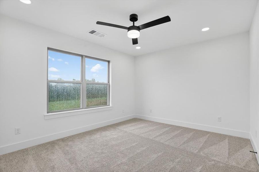Contemporary room featuring a large window, plush carpet, recessed lighting, and a modern ceiling fan