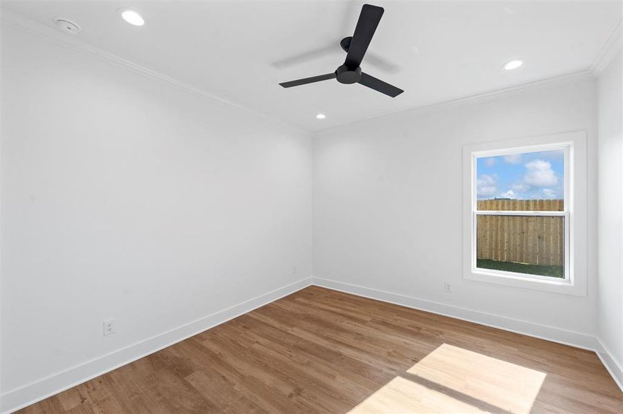 Empty room featuring crown molding, recessed lighting, wood finished floors, ceiling fan, and a smoke detector