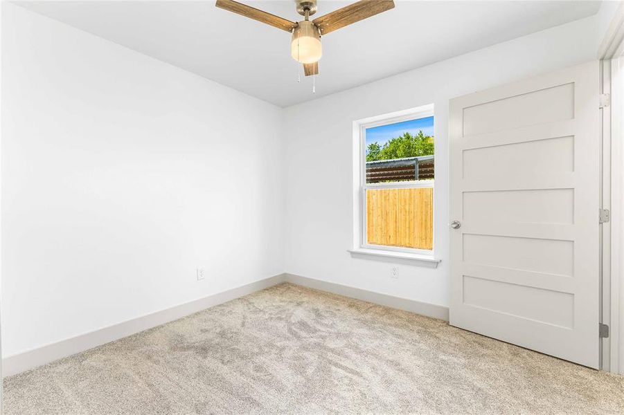 Empty room featuring carpet floors, ceiling fan, and baseboards Empty room featuring carpet floors, ceiling fan, and baseboards
