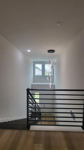 Stairs with recessed lighting, wood finished floors, baseboards, and an inviting chandelier
