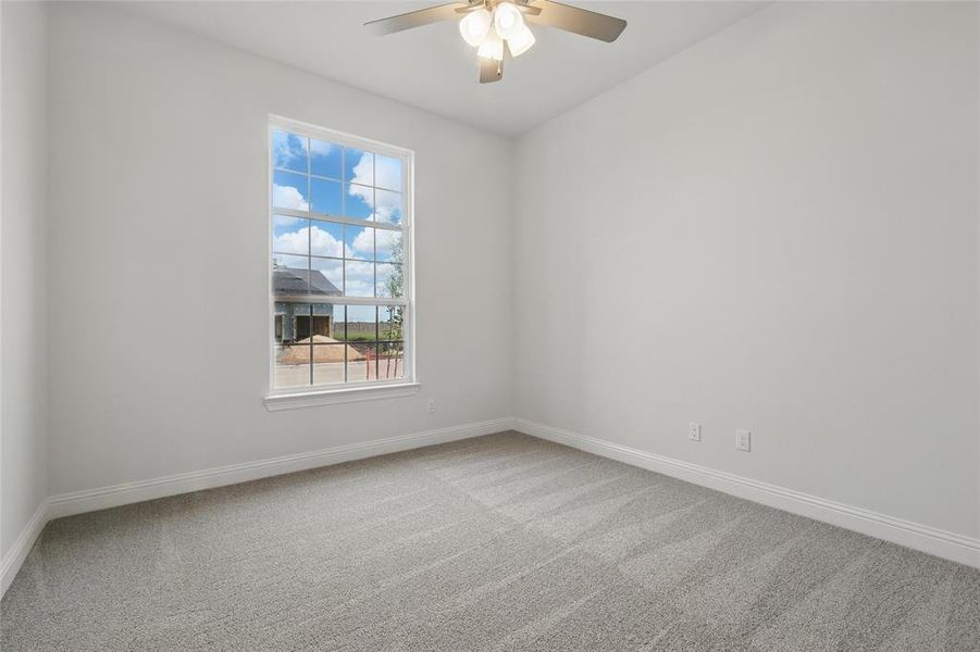 Carpeted spare room featuring baseboards and ceiling fan Carpeted spare room featuring baseboards and ceiling fan