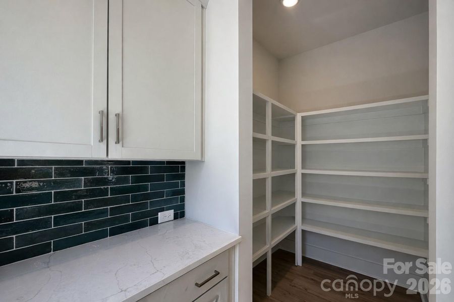 Impressive Walk In Pantry with Wood Shelving