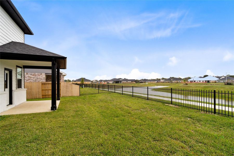 The covered back patio extends your living space outdoors, leading to a spacious, fully sodded yard and a black wrought-iron fence that showcases the beautiful water views and walking trails. The covered back patio extends your living space outdoors, leading to a spacious, fully sodded yard and a black wrought-iron fence that showcases the beautiful water views and walking trails.