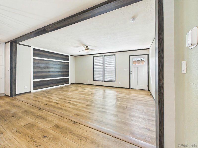 Living Area – Open living area with wide-plank flooring, ceiling fan, and a flexible layout that connects seamlessly to adjacent spaces.