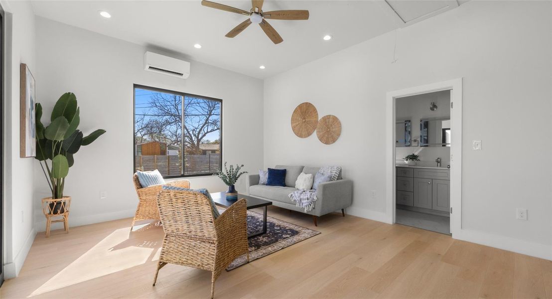 Living area with light wood-type flooring, ceiling fan, and recessed lighting
