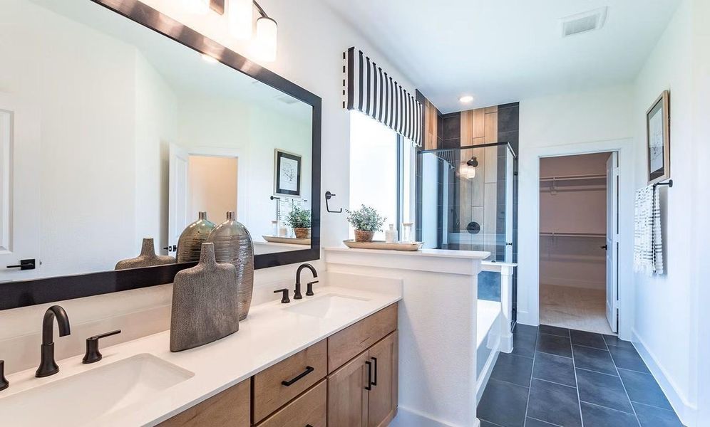Primary bathroom vanity area highlighting dual sinks, elegant finishes, and ample counter space designed for convenience and style. **Photos are representative only and may vary as built.**