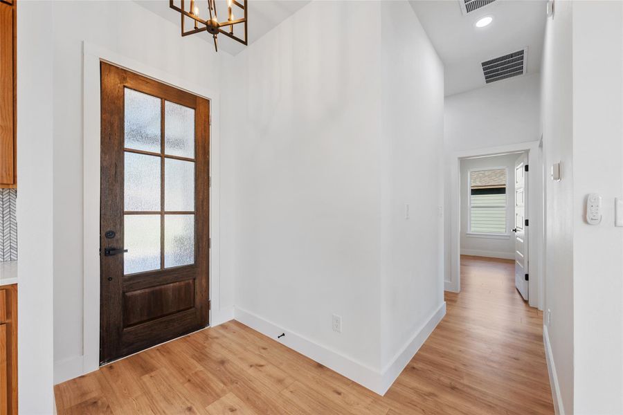 Entrance foyer with light wood-style floors, recessed lighting, and a chandelier