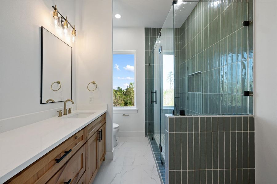 Bathroom featuring vanity, light marble finish floors, a stall shower, and recessed lighting