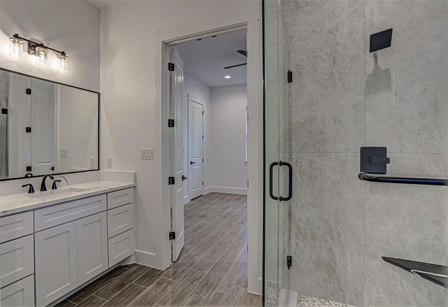 2nd Full bathroom downstairs with vanity, wood tiled floors, and a shower 2nd Full bathroom downstairs with vanity, wood tiled floors, and a shower