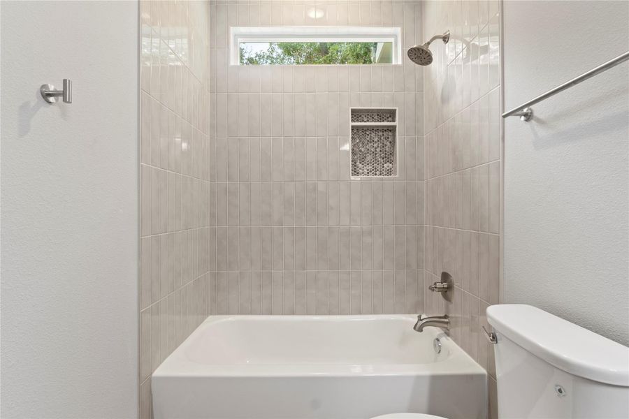 A stunning, spacious bathroom with a sleek vanity, a bath-shower combo, and radiant natural light. A stunning, spacious bathroom with a sleek vanity, a bath-shower combo, and radiant natural light.