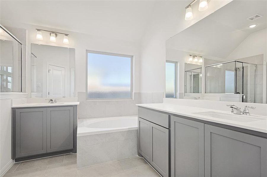 Bathroom with vanity, tile patterned flooring, plus walk in shower, and lofted ceiling