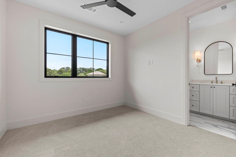 Unfurnished bedroom featuring a sink, baseboards, ensuite bathroom, and light colored carpet