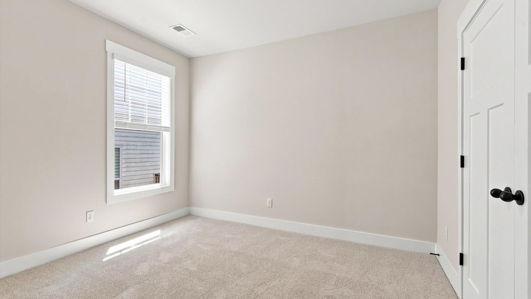 First-class secondary bedroom with comfortable carpeted flooring and generous closet space
