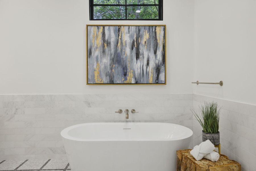 Full bath with tile walls, a freestanding tub, and wainscoting