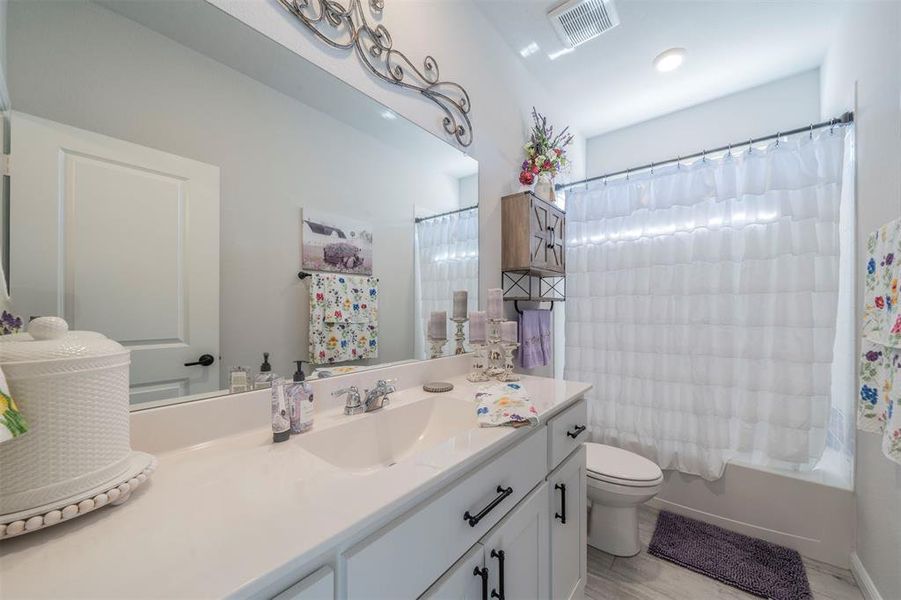 Full bathroom with vanity, toilet, and shower / tub combo with curtain