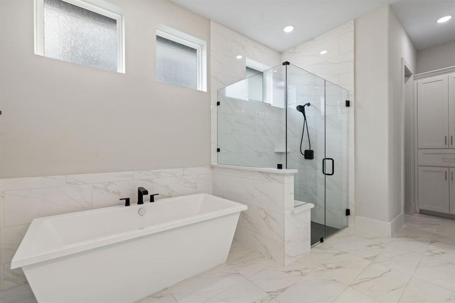Bathroom featuring a soaking tub, a marble finish shower, marble finish flooring, tile walls, and recessed lighting