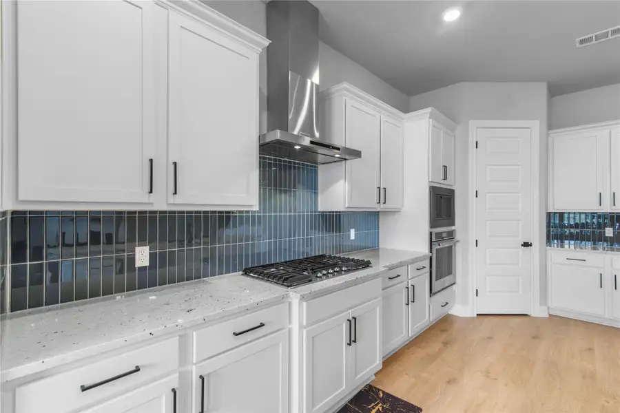 Spacious kitchen with a sleek 5-burner gas cooktop and ample counter space for easy meal prep.
