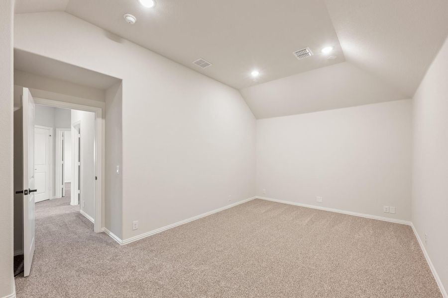 Empty bedroom with vaulted ceiling, beige carpet, white walls, and recessed lighting Empty bedroom with vaulted ceiling, beige carpet, white walls, and recessed lighting