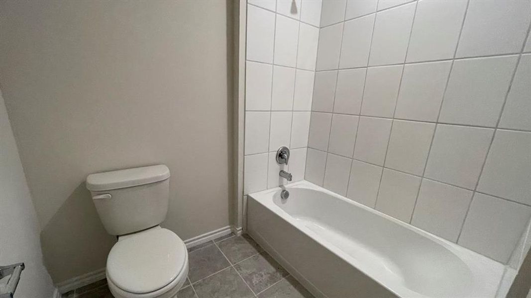 White tile tub and shower combination with chrome fixtures