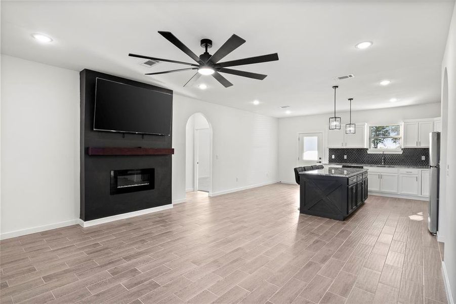 Kitchen with dark cabinets, open floor plan, decorative light fixtures, recessed lighting, and white cabinetry