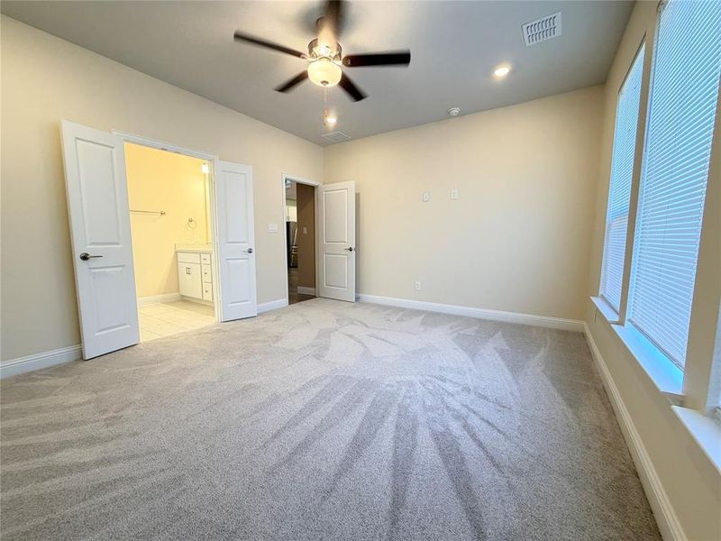 Unfurnished bedroom featuring light colored carpet, ensuite bath, a ceiling fan, and recessed lighting Unfurnished bedroom featuring light colored carpet, ensuite bath, a ceiling fan, and recessed lighting
