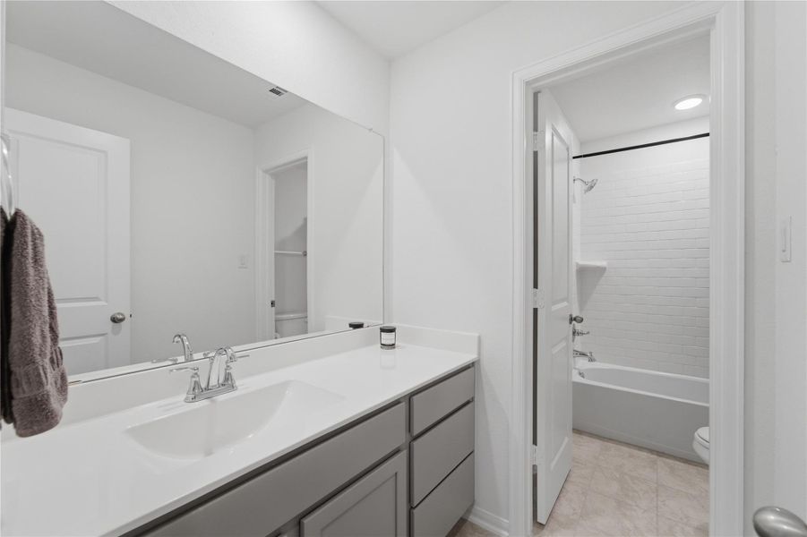 A well-appointed bathroom features a single vanity with ample counter space and a classic shower-over-tub design. A well-appointed bathroom features a single vanity with ample counter space and a classic shower-over-tub design.