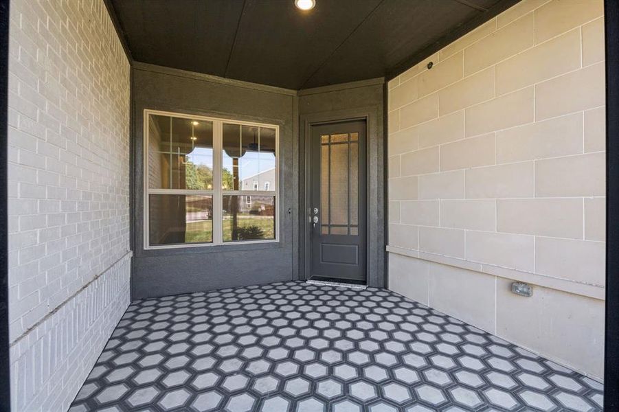 Large, welcoming front patio with decorative tile.