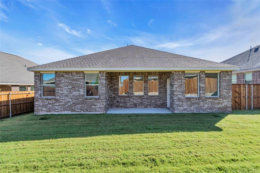 Back of property with a lawn and a patio area