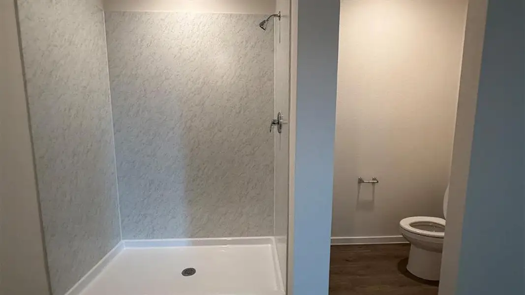 Stand-up shower with textured wall panels and a white shower pan Stand-up shower with textured wall panels and a white shower pan