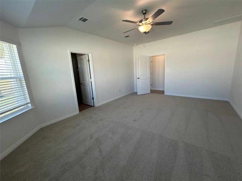 Unfurnished bedroom with carpet flooring, ceiling fan, and vaulted ceiling