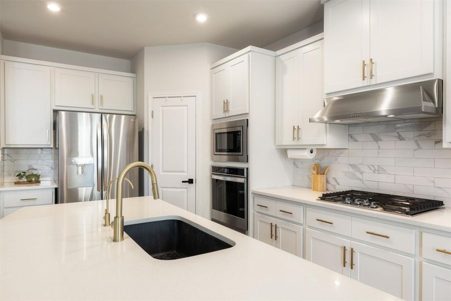 Grey cabinetry with gold hardware sets a warm, updated look that anchors the entire kitchen