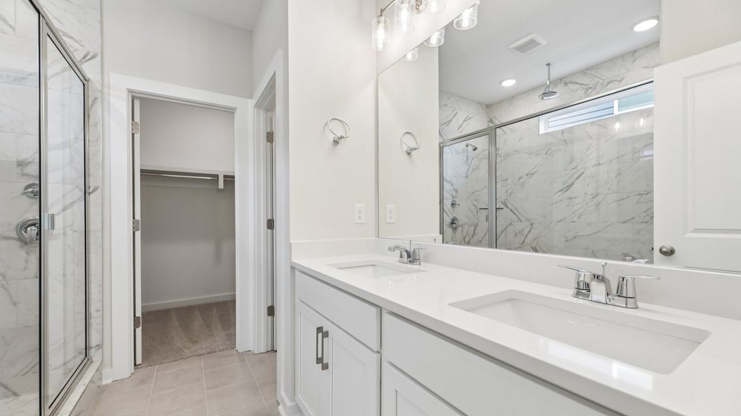 Primary bathroom with dual vanity and access to closet Primary bathroom with dual vanity and access to closet