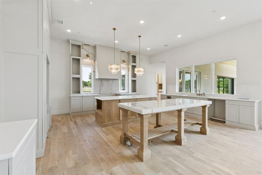 The gourmet kitchen is a true masterpiece with two oversized islands, Cristallo quartz counters, commercial grade Bertazzoni appliances, 48in dual-fuel range with 6 burners plus griddle, double oven and convection, 60in built-in refrigerator and freezer, and range hood with state-of-the-art ventilation system.