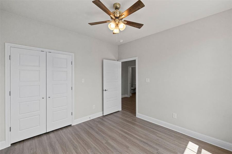 Unfurnished bedroom featuring a closet, light hardwood / wood-style floors, and ceiling fan