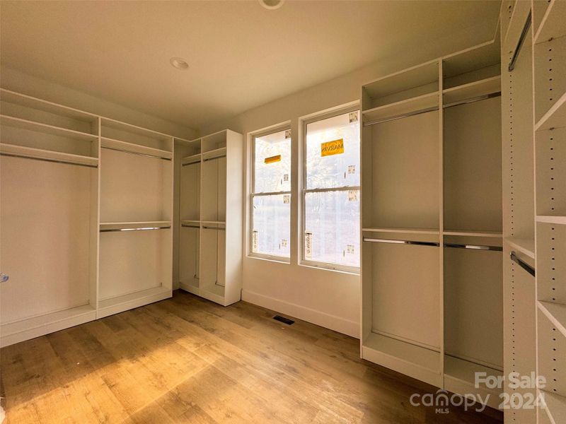 Customizable primary walk-in closet with built-ins and abundant natural light.