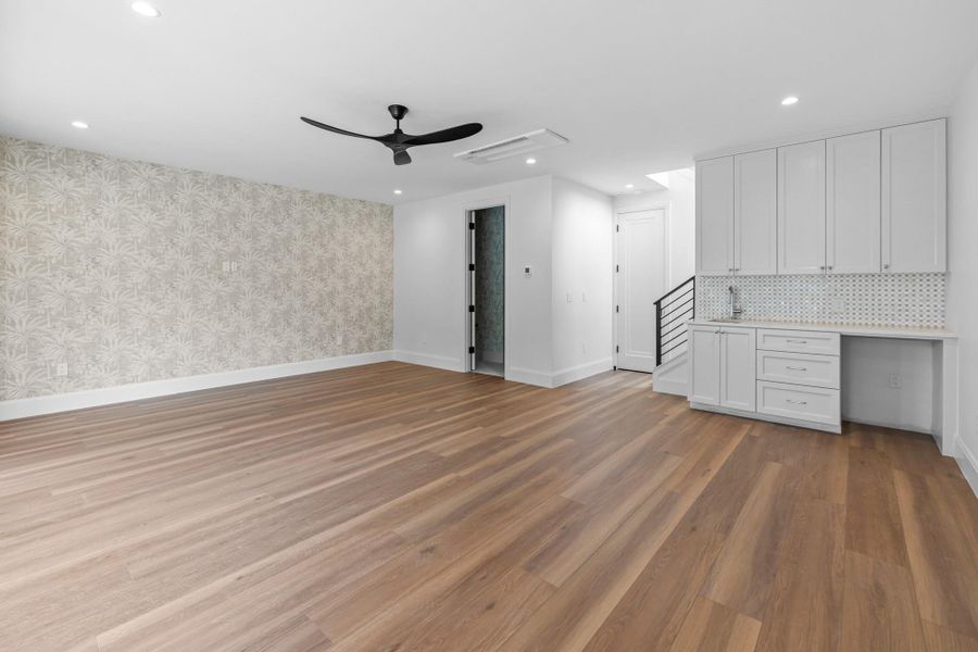 Unfurnished living room featuring wallpapered walls, a ceiling fan, recessed lighting, light wood-style flooring, and baseboards