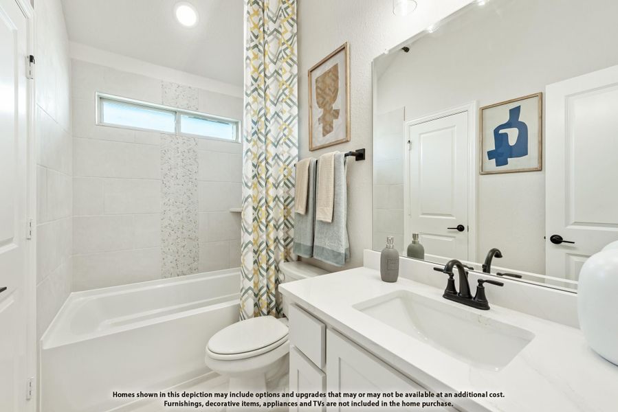 Bathroom with white vanity, tub-shower combo with patterned curtain, and large mirror Bathroom with white vanity, tub-shower combo with patterned curtain, and large mirror